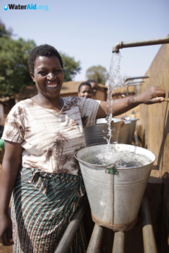 A lady in Malawi fills a bucket with clean water
